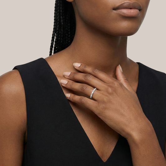 Woman wearing a black sleeveless top with a neutral background