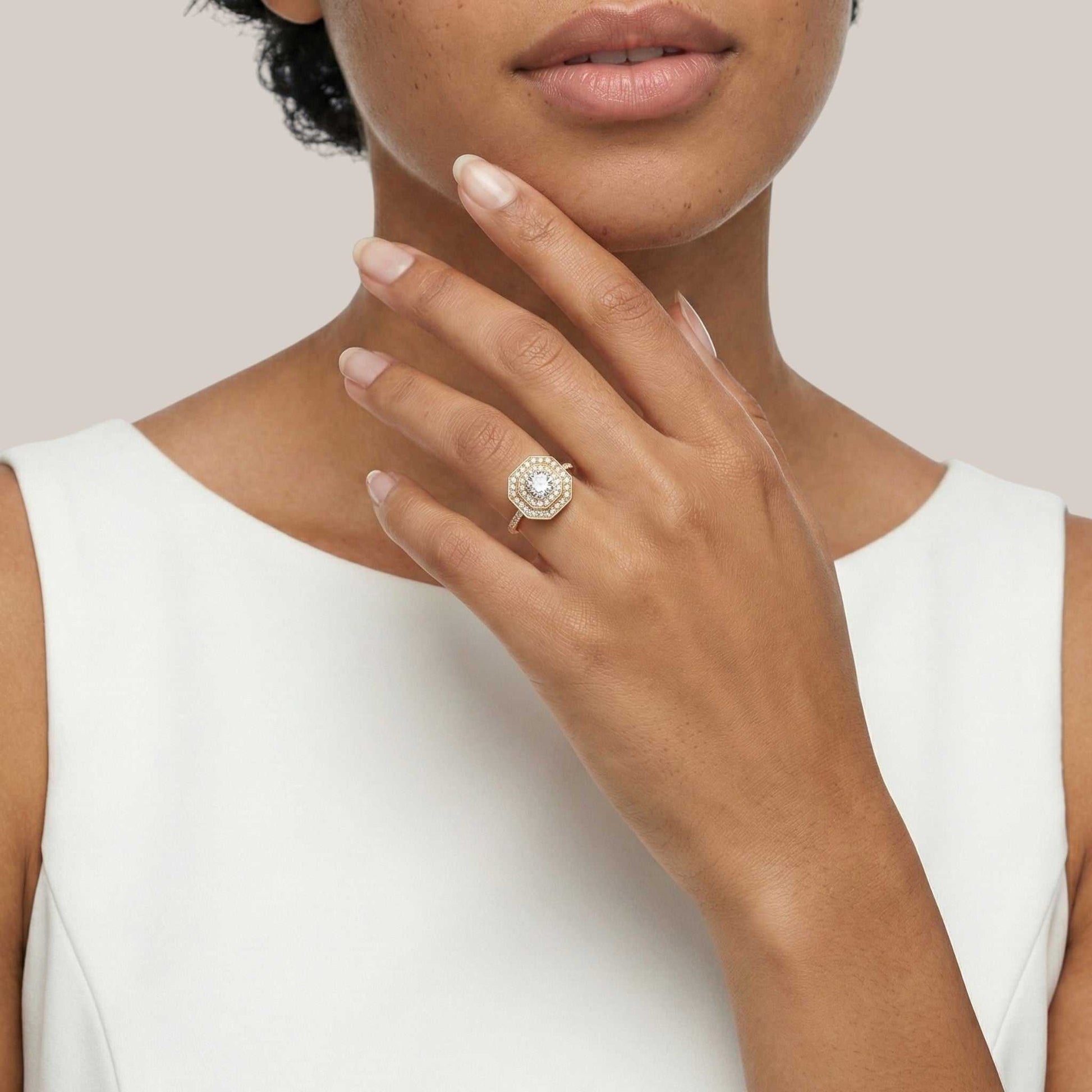 Close-up of a woman's hand wearing a diamond ring on a plain background