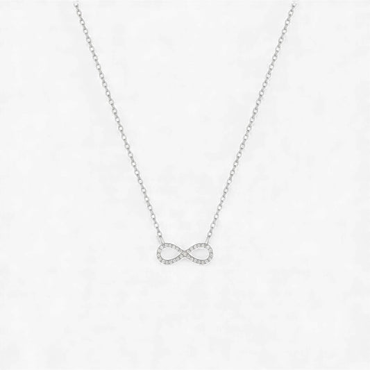 Silver infinity necklace on a light gray background