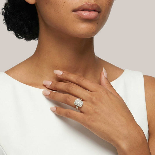 Close-up of a person wearing a diamond ring on a plain background