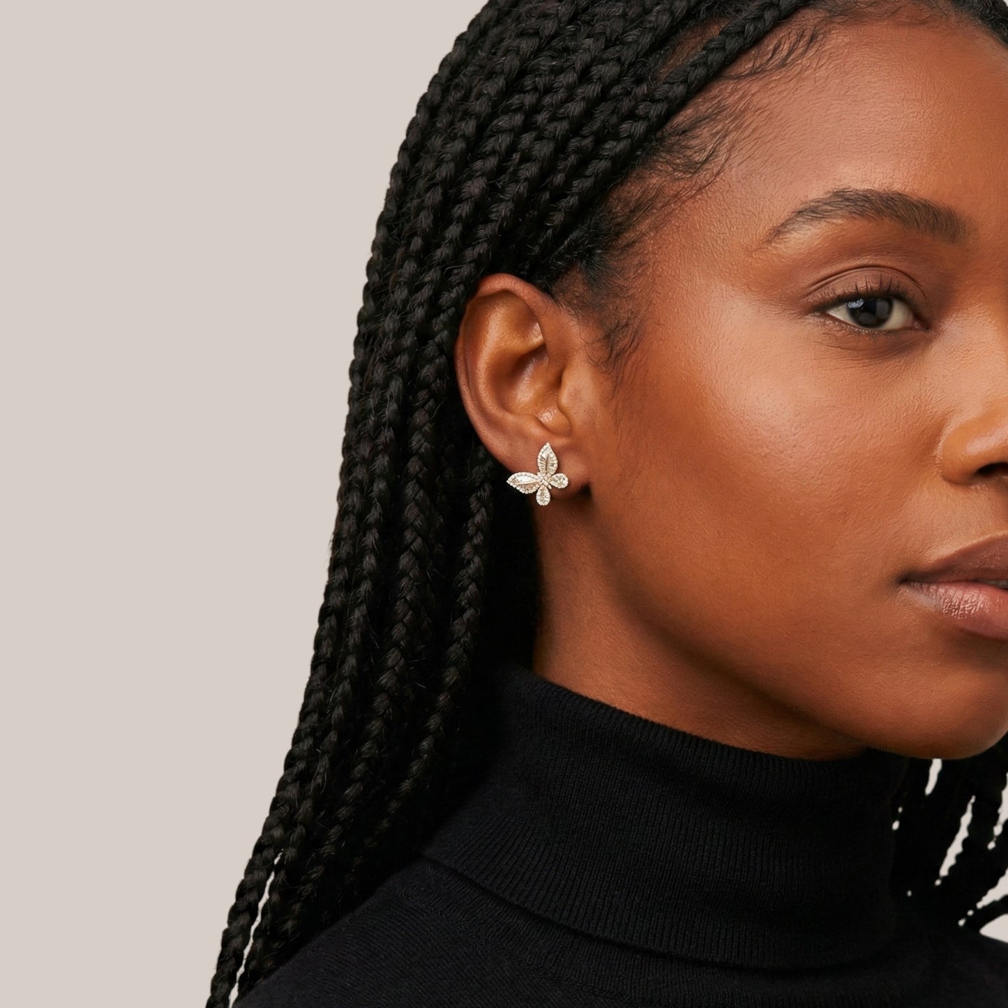Close-up of a woman wearing a floral earring with a plain background