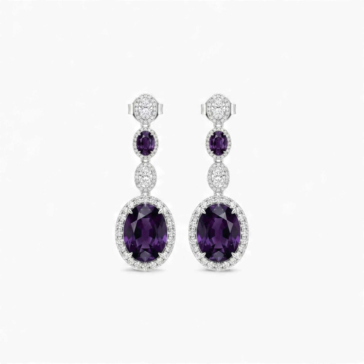 Pair of purple gemstone earrings with silver accents on a white background