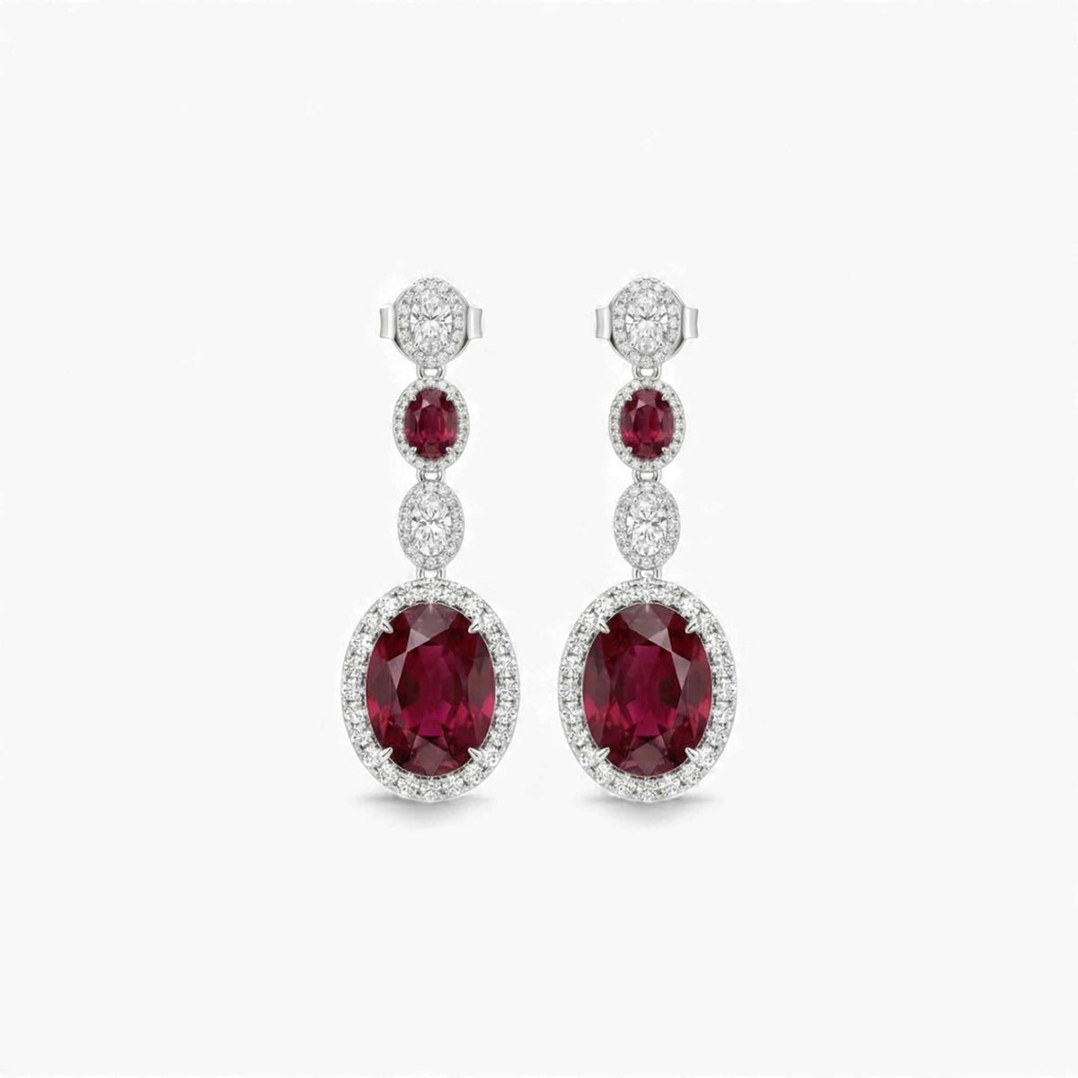 Pair of red gemstone earrings with diamond accents on a white background