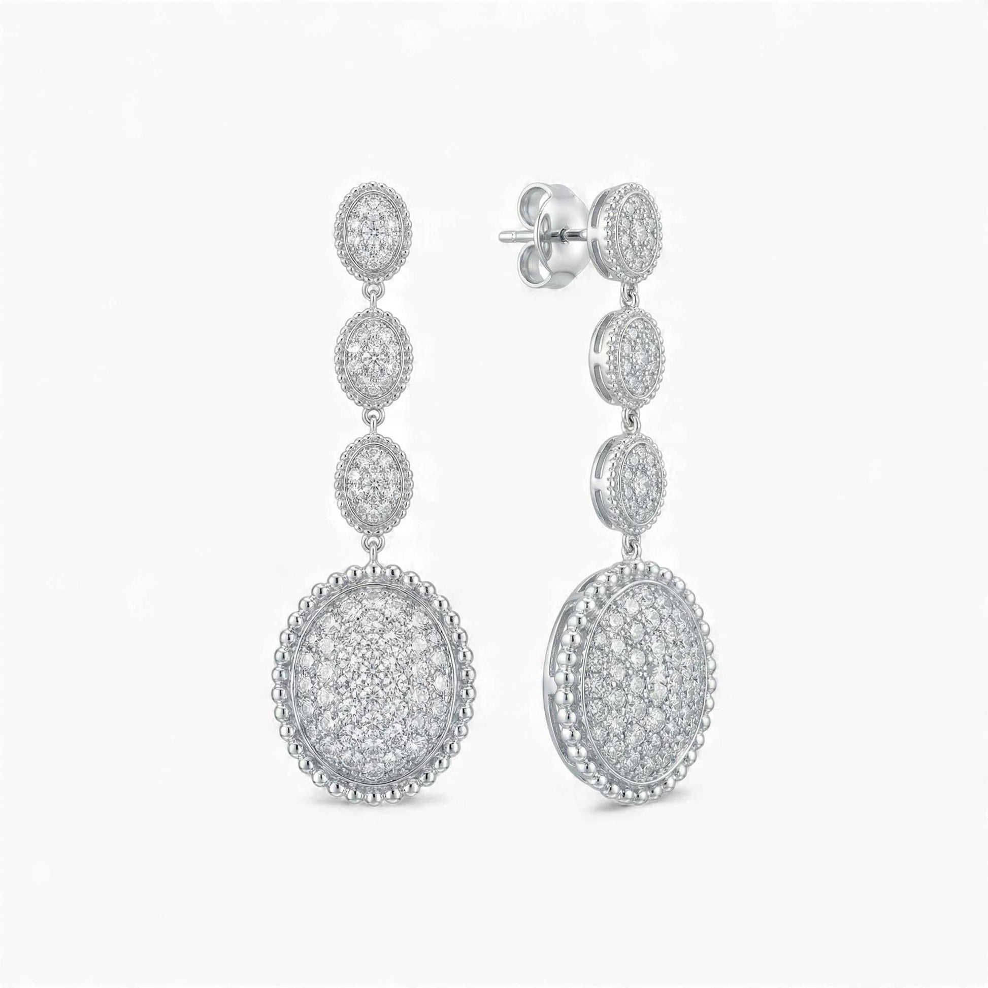 Pair of silver earrings with circular designs on a white background