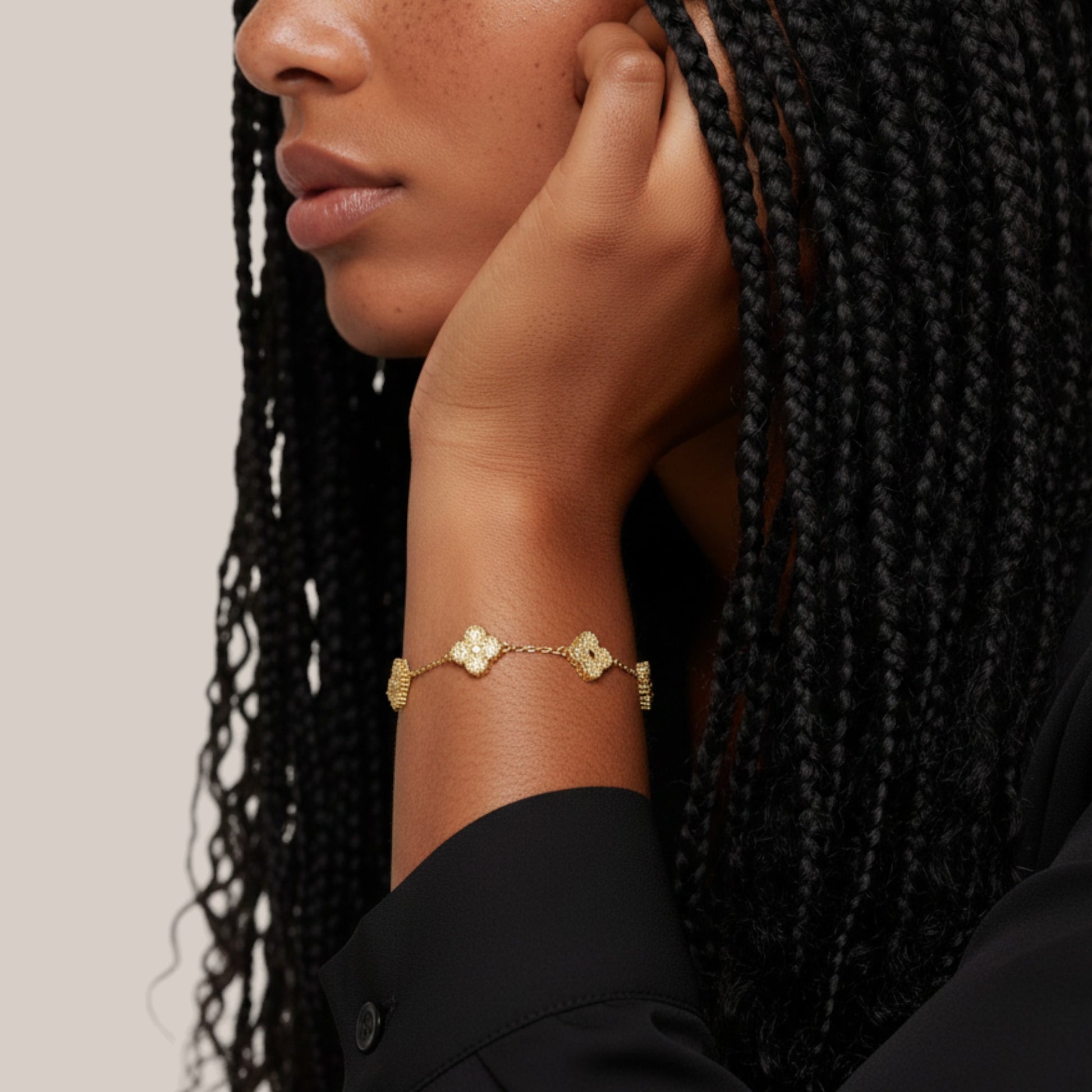 Woman wearing a gold bracelet with a subtle design on a neutral background