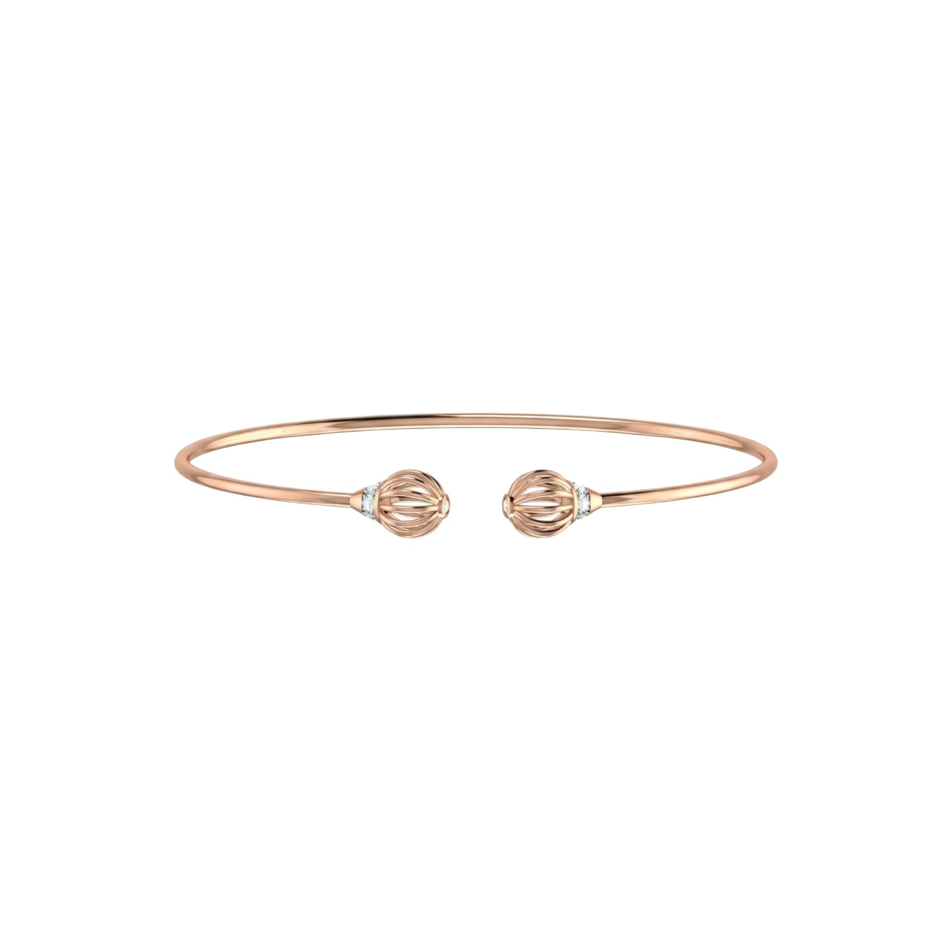 Rose gold bracelet with two spherical charms on a white background