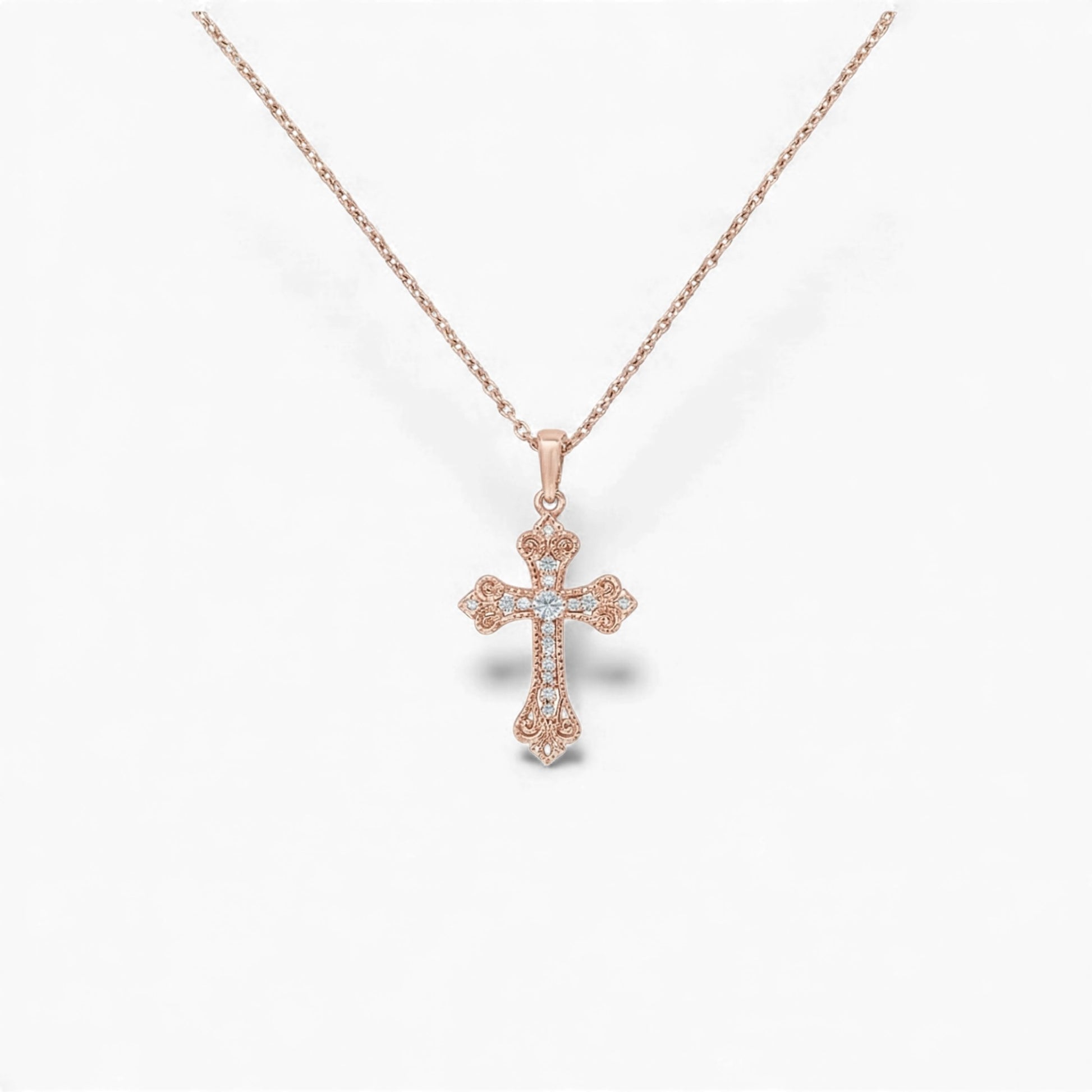 Rose gold cross necklace on a white background