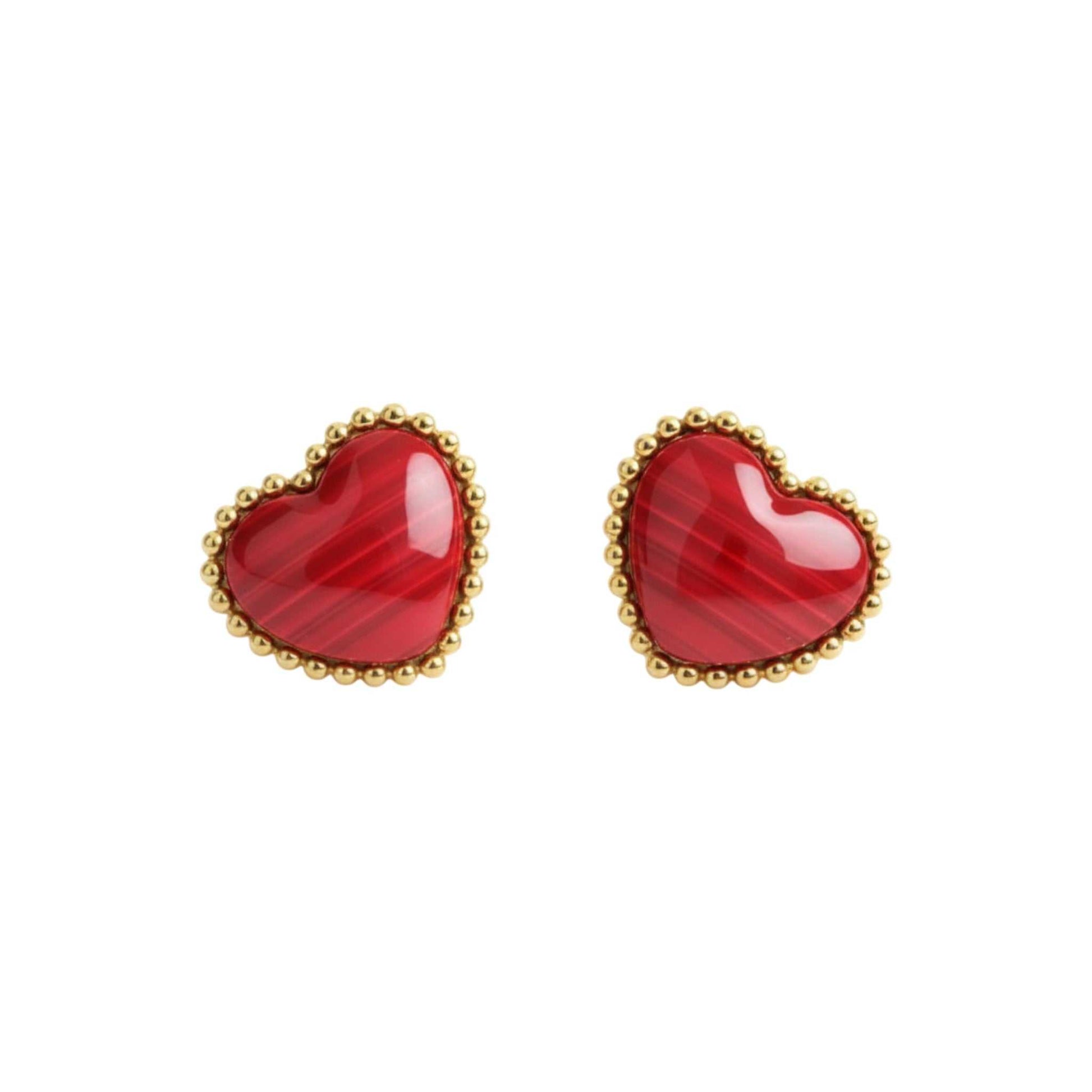 Red heart-shaped earrings with gold accents on a white background