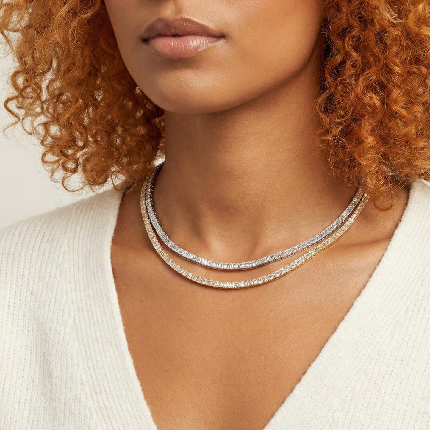 Close-up of a woman wearing a silver necklace with a neutral background