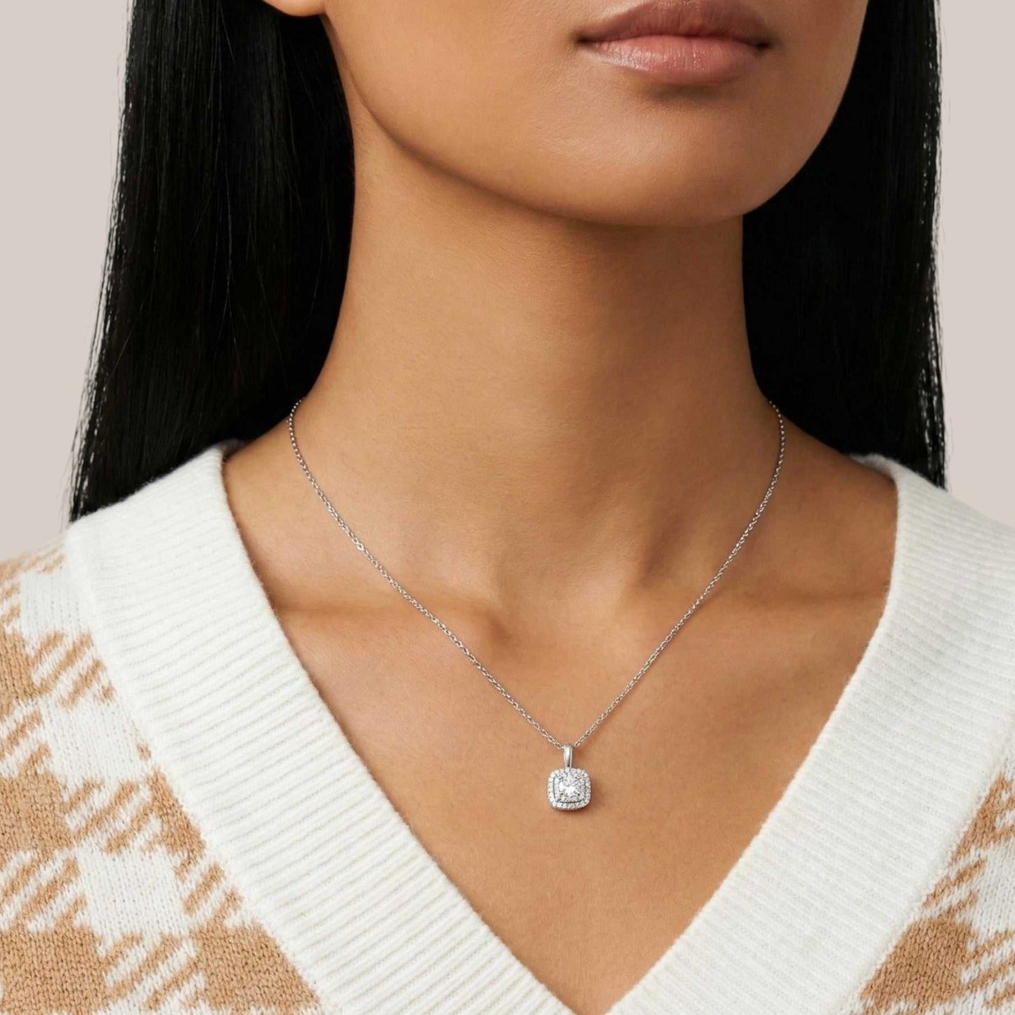 Necklace with a pendant worn by a person against a neutral background