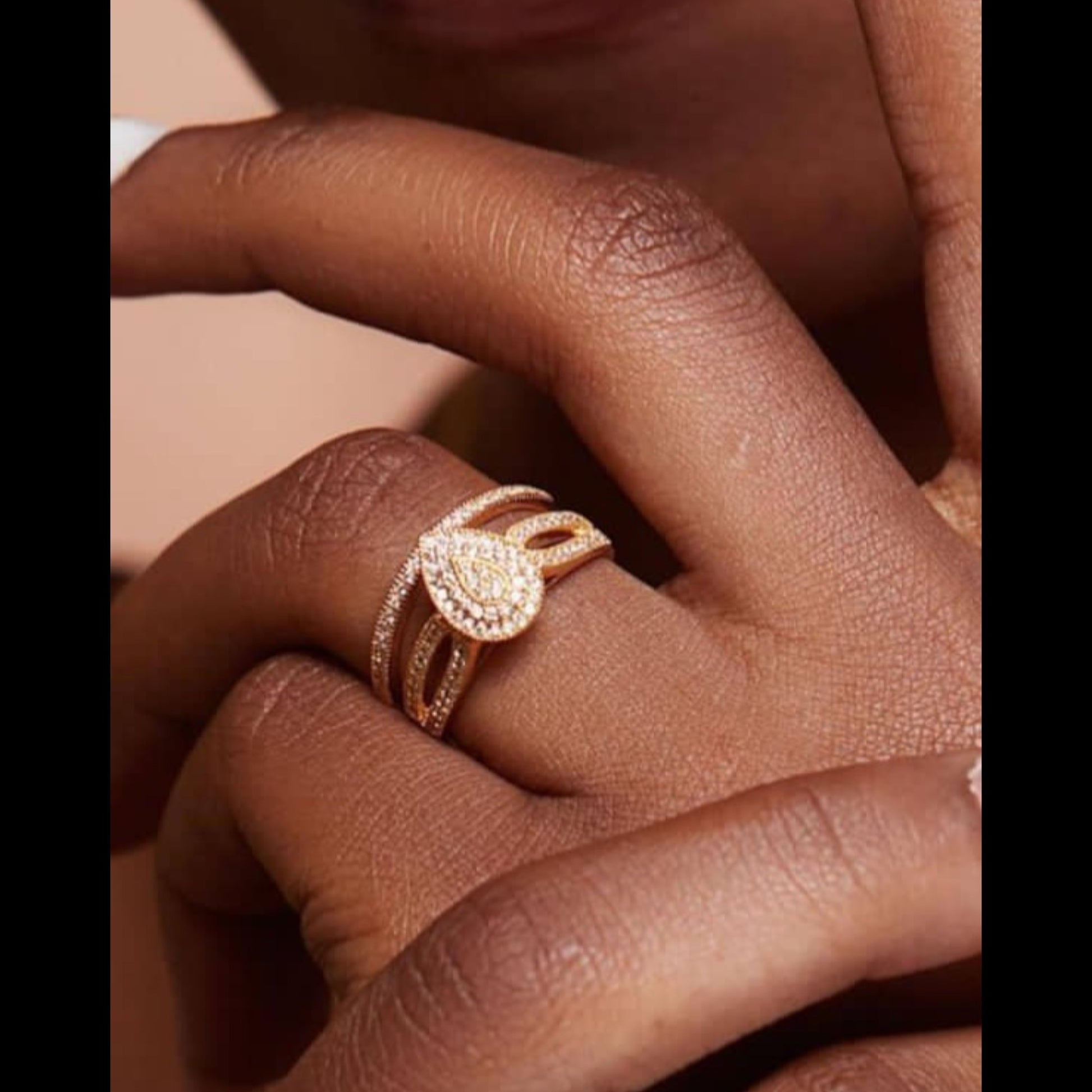 Rose gold ring on a person's finger with a soft background