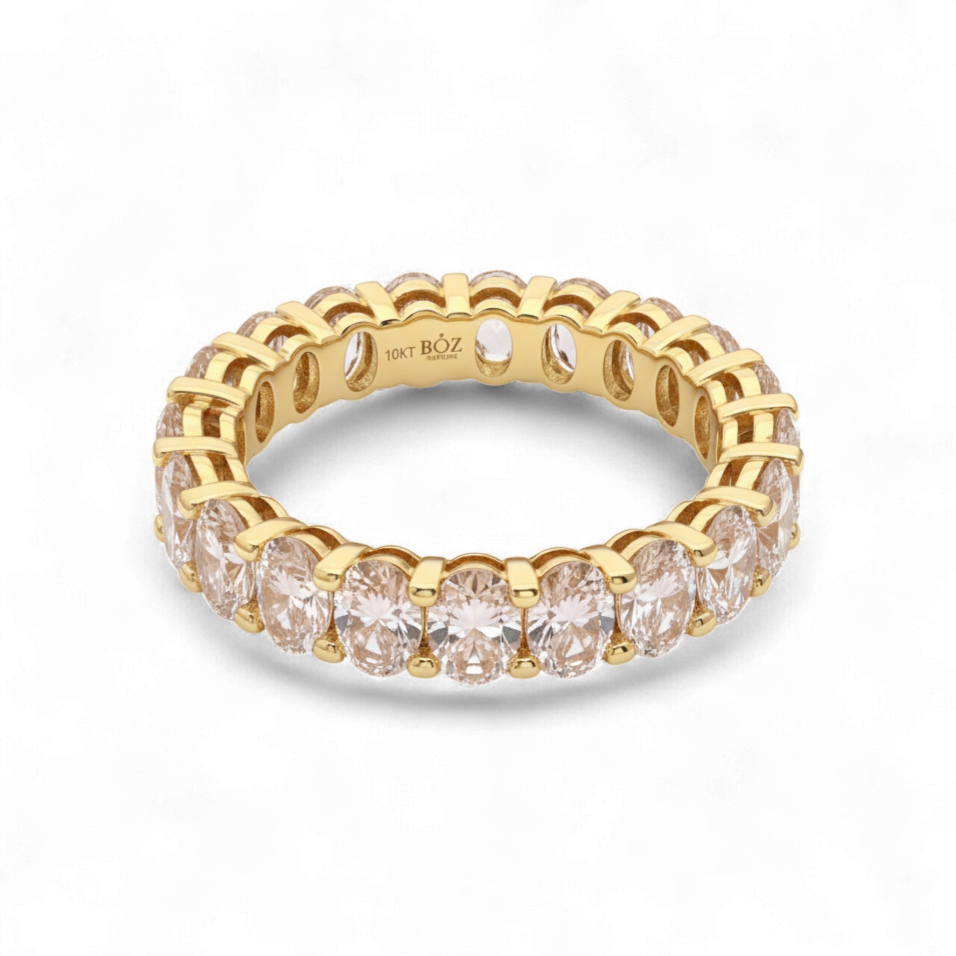 Gold ring with clear gemstones on a white background