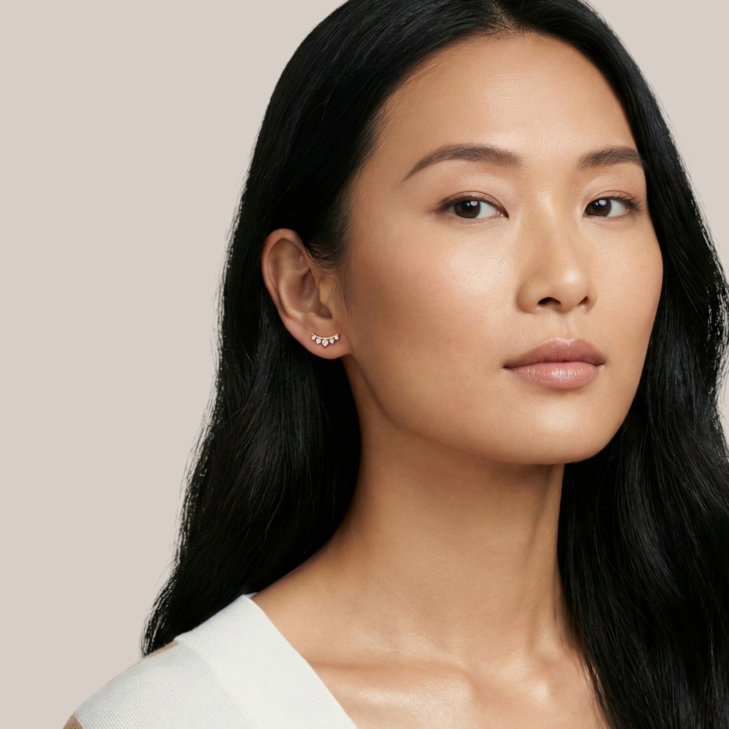 Woman wearing a white top against a beige background