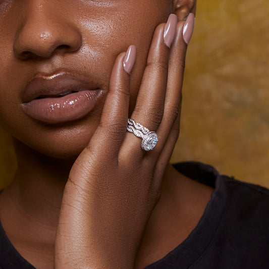 Close-up of a woman's hand wearing a diamond ring with a blurred background