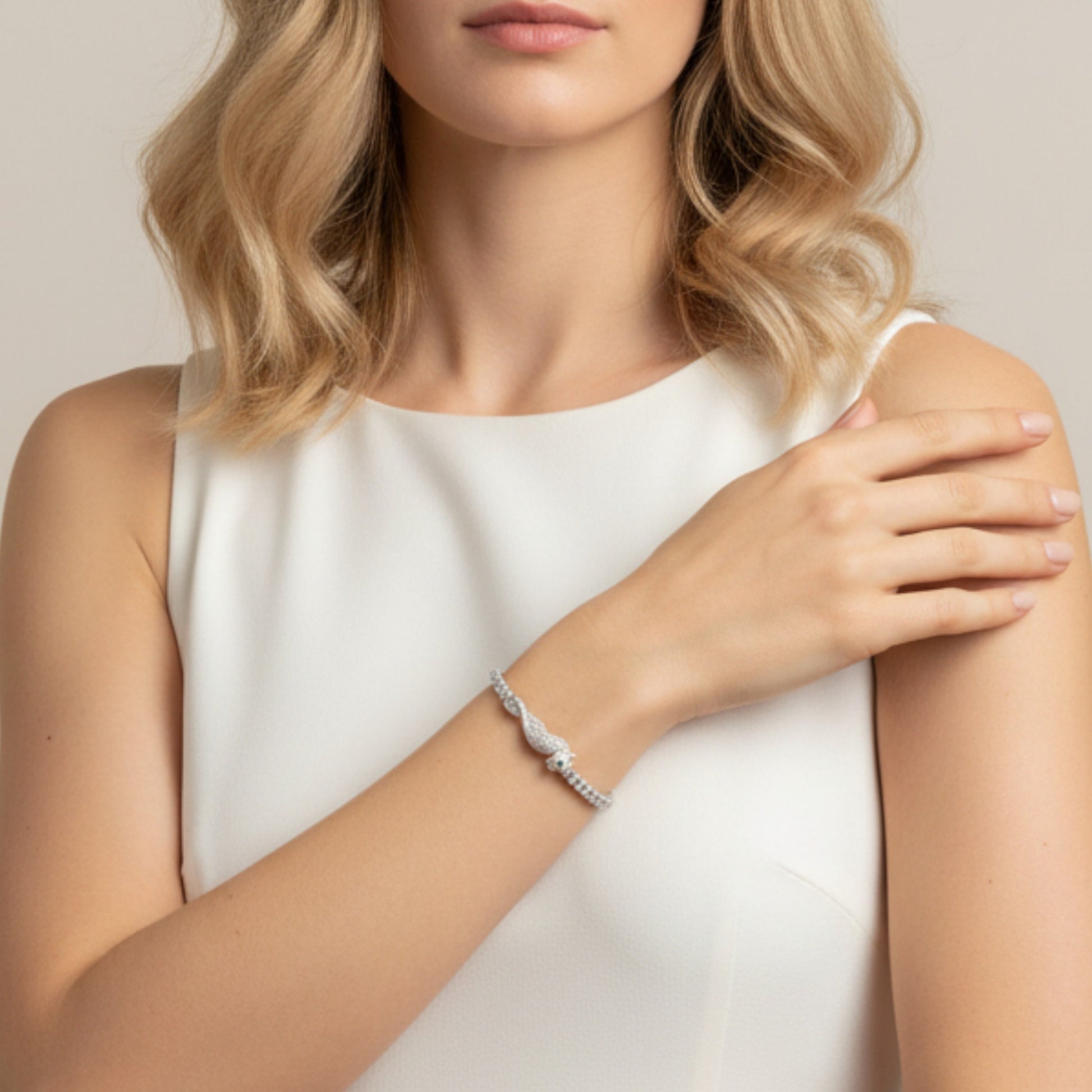 Woman wearing a silver bracelet on a plain background