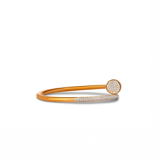 An 18 karat gold nail cuff bracelet with natural diamond accents.