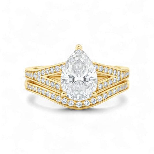 Gold ring with a pear-shaped diamond on a white background