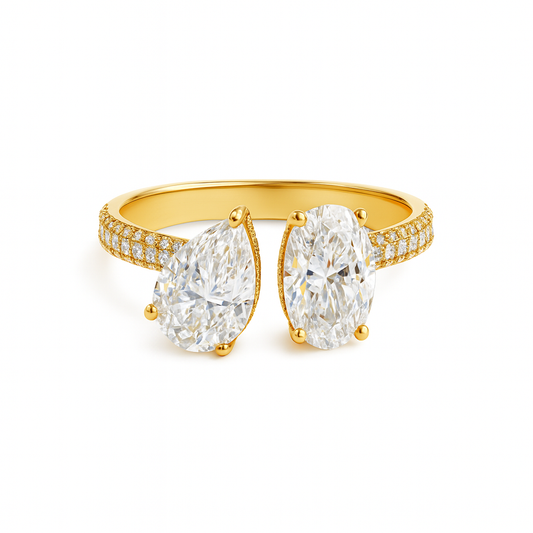 Gold ring with two large pear-shaped diamonds on a white background