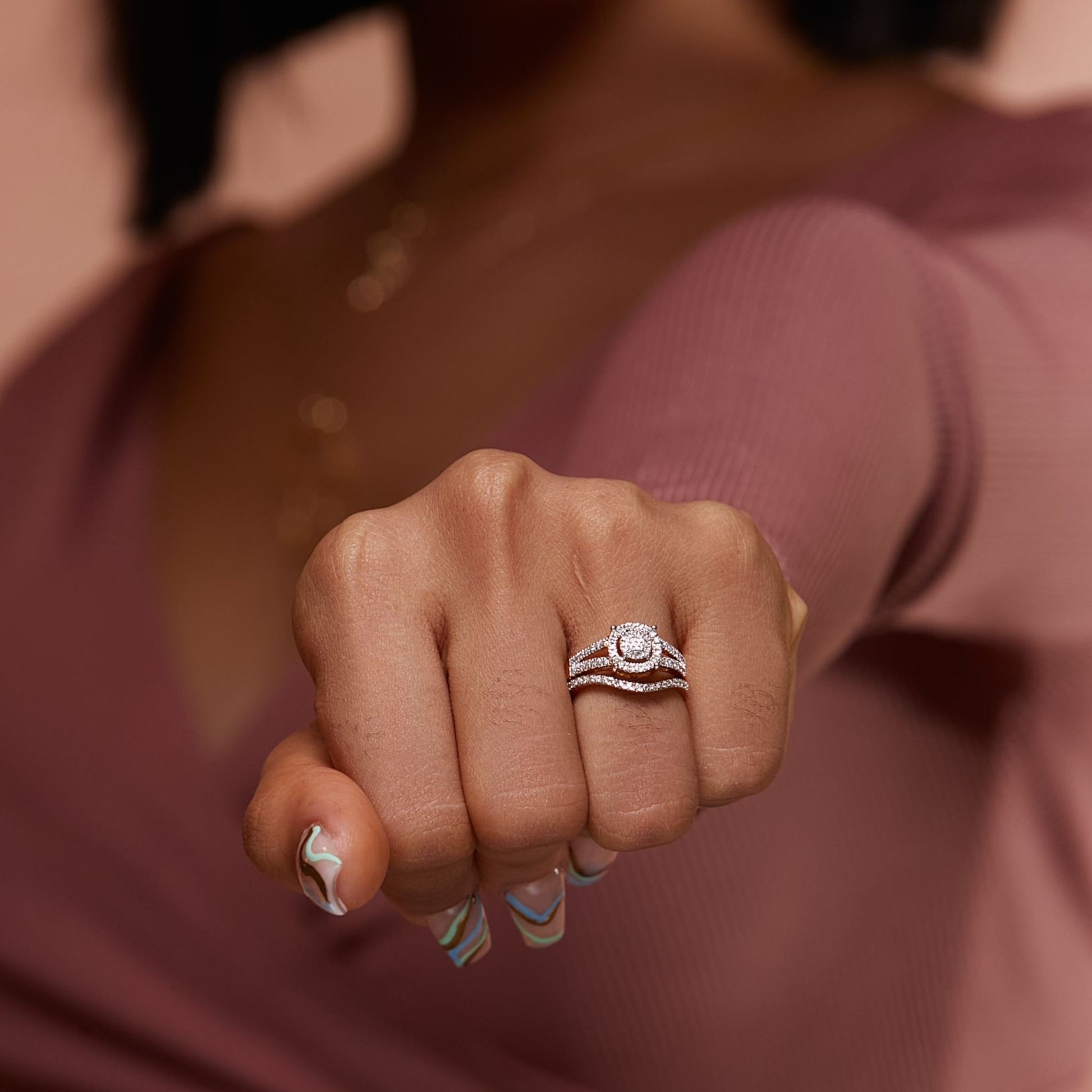 Close-up of a person's hand wearing a ring with a blurred background