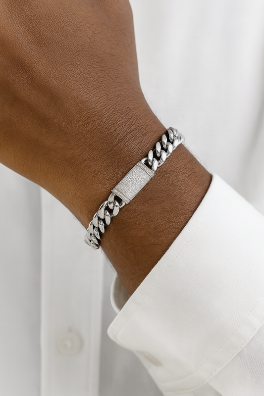 Silver chain bracelet on a wrist with a white shirt background