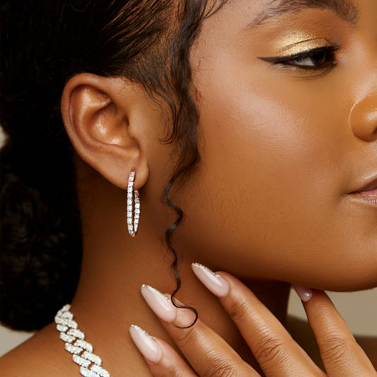 Close-up of a woman wearing diamond hoop earrings and a pearl necklace.