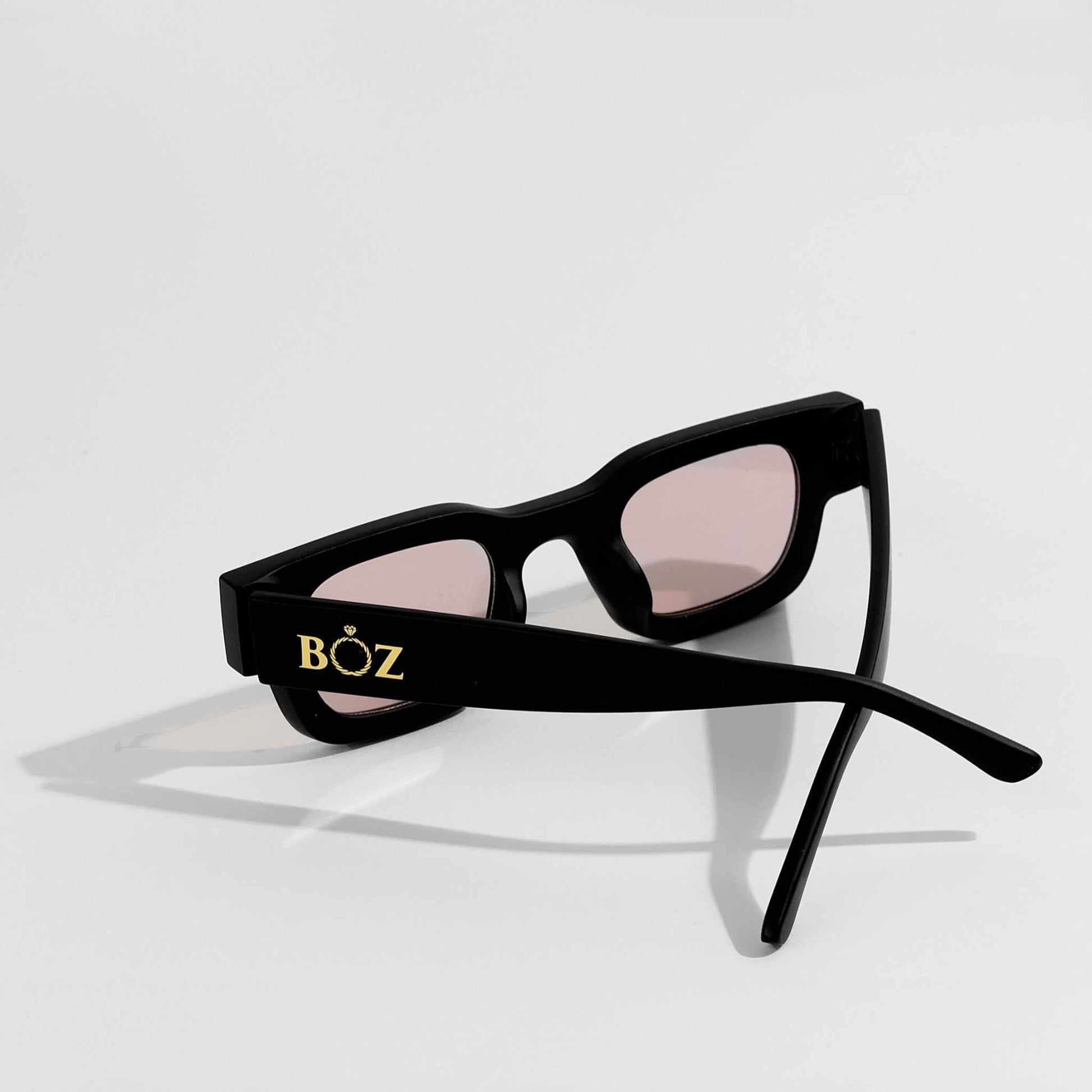 Black sunglasses with pink lenses on a white background, featuring the brand 'BOZ'.