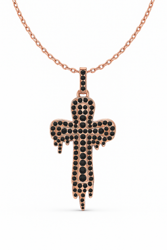 Rose gold cross pendant with black stones on a white background