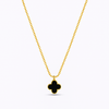 Gold necklace with a black clover pendant on a white background