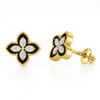 Butterfly-shaped gold earrings with black and white details on a white background