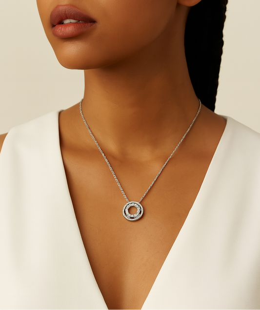 Woman wearing a silver necklace with a circular pendant on a beige background