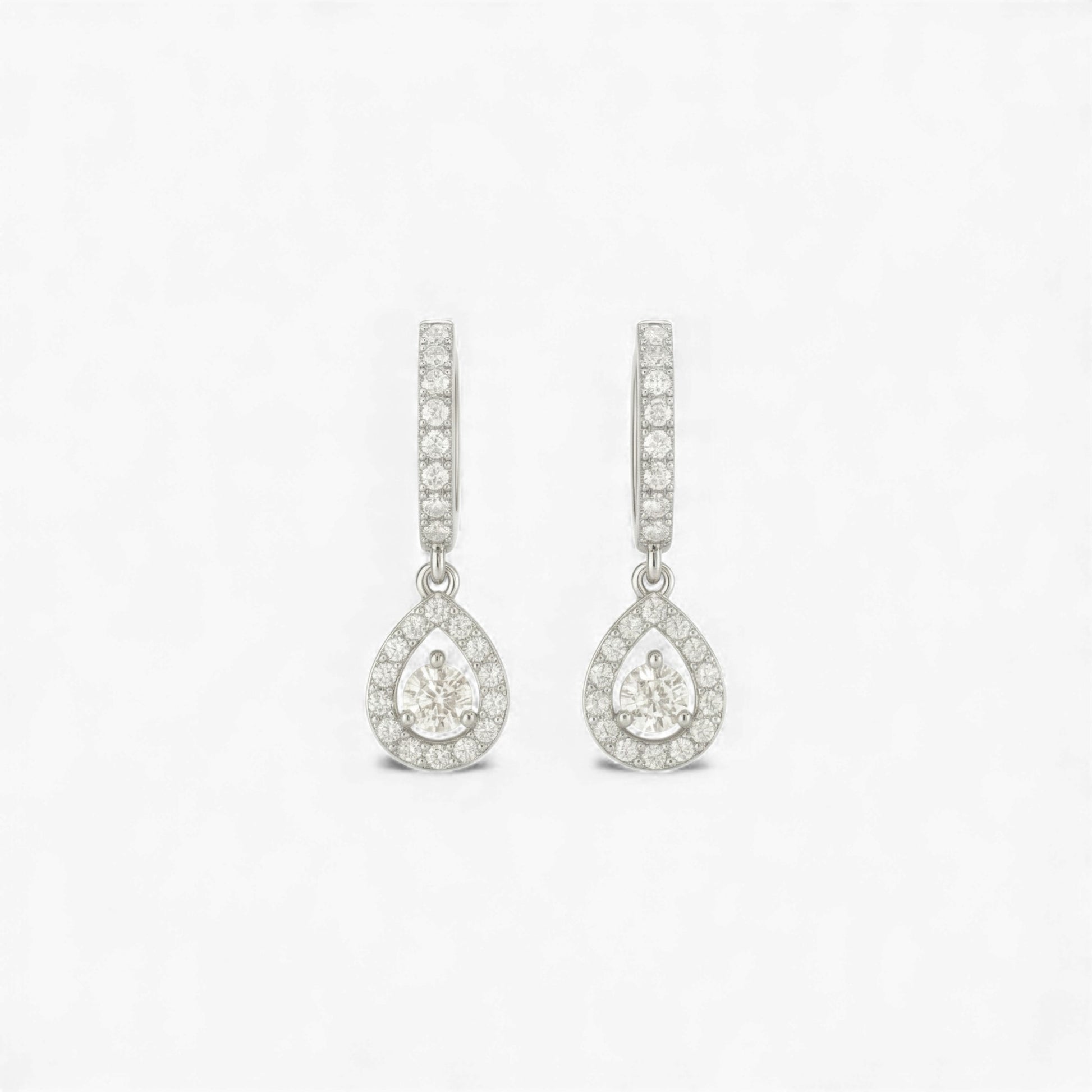 Teardrop-shaped earrings with clear gemstones on a light gray background