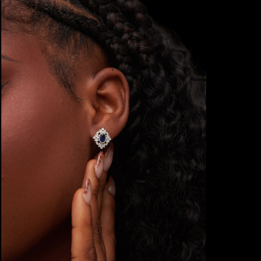 Close-up of an ear wearing a decorative earring with a dark background