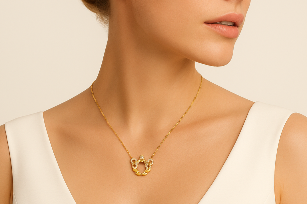 Woman wearing a gold necklace against a beige background