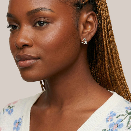 Woman wearing a white floral sweater with a neutral background