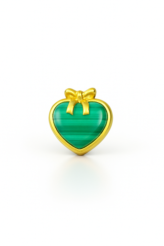 Heart-shaped green stone with gold border and bow on a white background