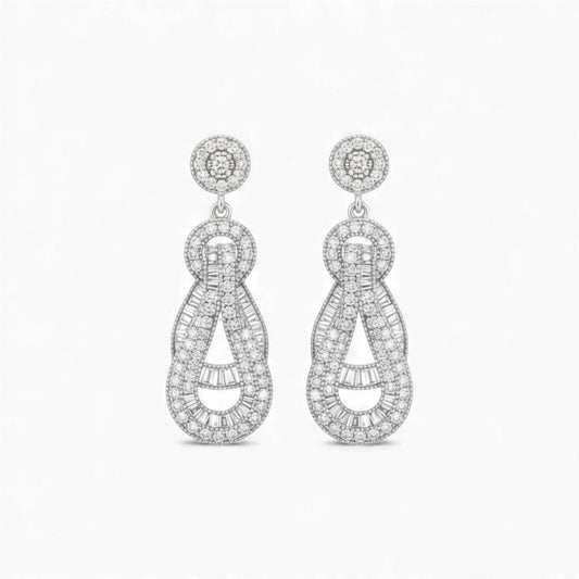 Pair of silver earrings with intricate designs on a white background