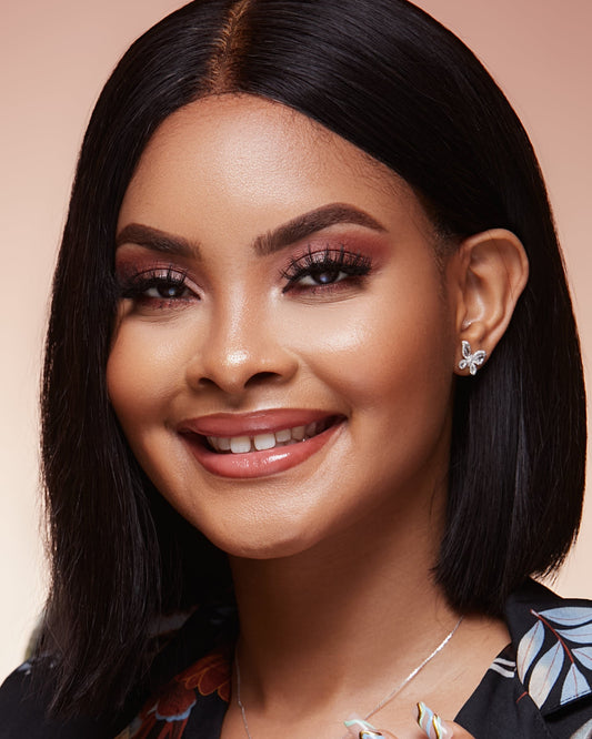 Woman with styled hair and makeup on a pink background