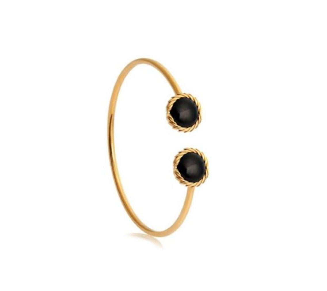 Gold bracelet with black beads on a white background