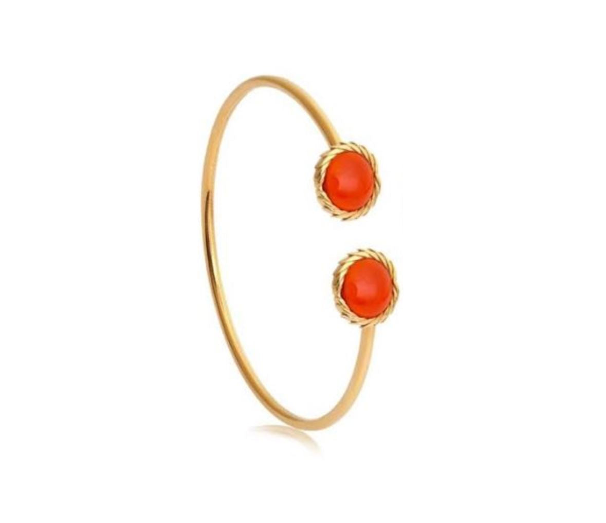 Gold bangle with two red stones on a white background