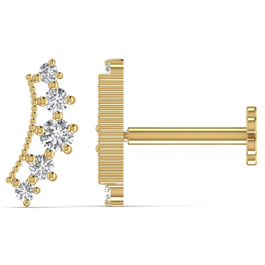 A pair of 18 karat gold labret cartilage stud earrings adorned with diamonds.