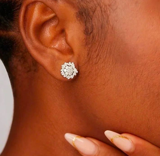 A close-up image of a person's ear wearing a moissanite stud earring, with the rest of the ear and part of the neck visible.