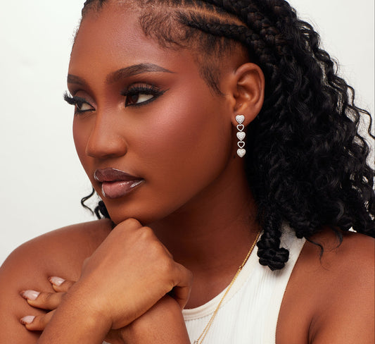 Woman wearing gold jewelry against a neutral background