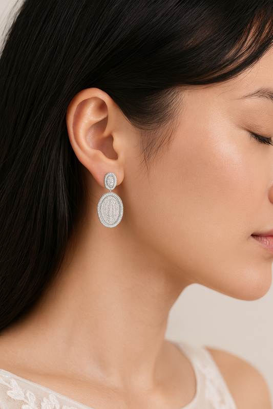 Close-up of a woman wearing silver earrings with a neutral background, featuring the BOZ Jewelry brand.