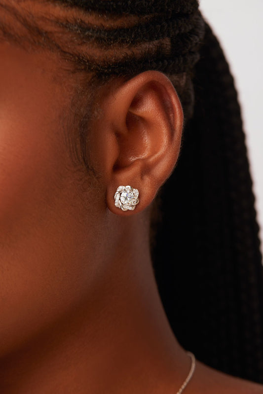 A person wearing a pair of Moonstone Moissanite stud earrings in 925 Sterling Silver.