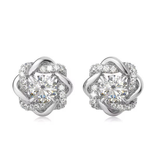 Pair of silver earrings with clear gemstones on a white background