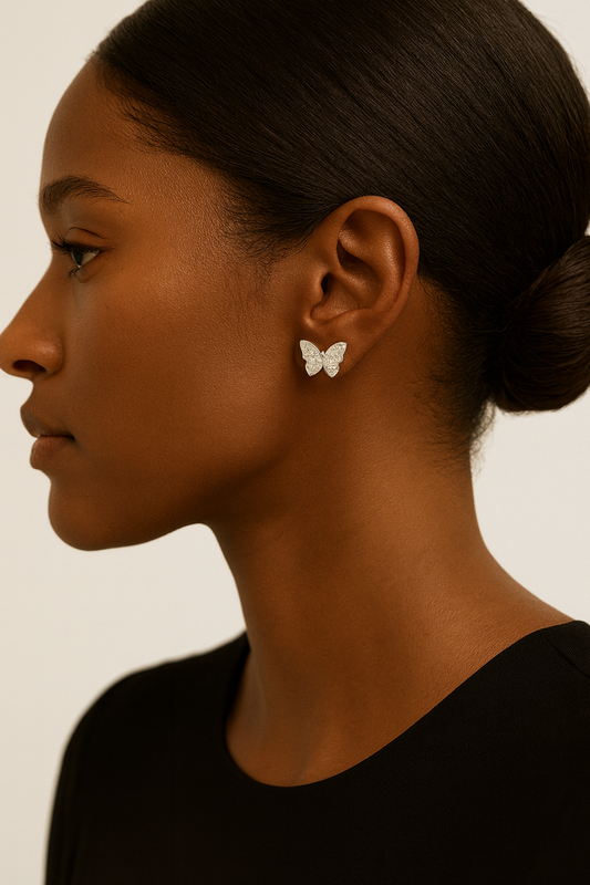 Woman wearing butterfly earrings with a neutral background