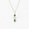 Gold necklace with a pendant featuring green gemstones on a white background