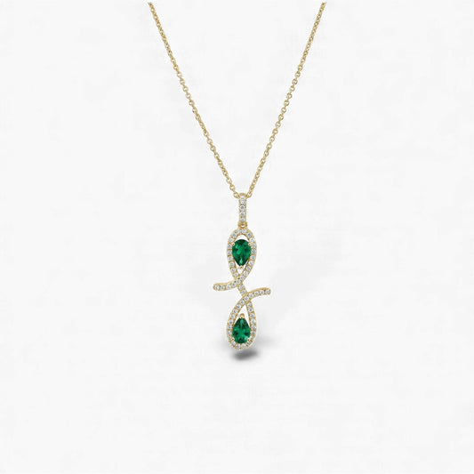 Gold necklace with a pendant featuring green gemstones on a white background