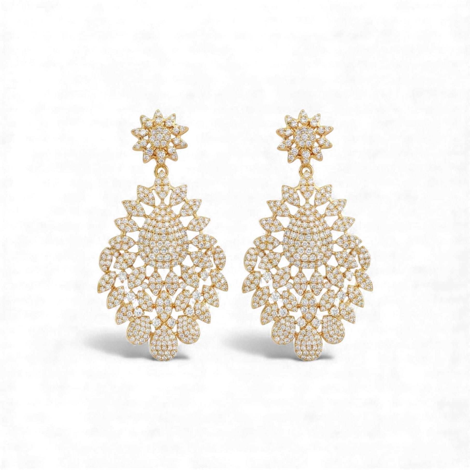 Pair of gold earrings with intricate designs on a white background