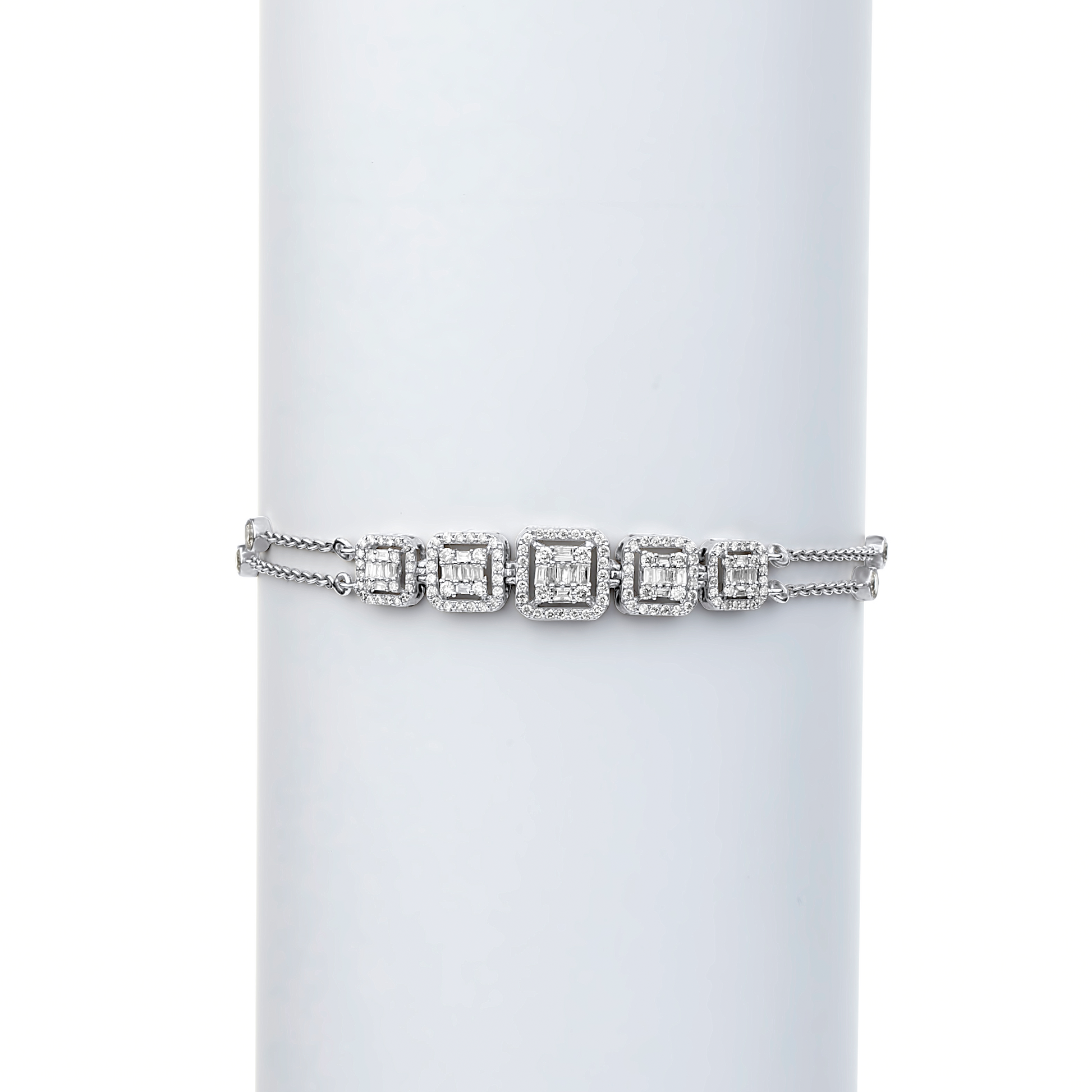 A tennis bracelet featuring natural diamonds set in 18 karat gold, displayed on a white cylindrical stand.